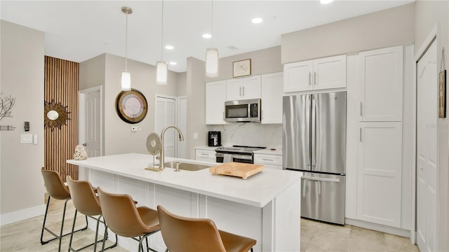 2627 Maitland Crossing Way Unit 101, Orlando, FL 32810 - kitchen featuring stainless steel appliances, a sink, white cabinets, a kitchen breakfast bar, and decorative backsplash
