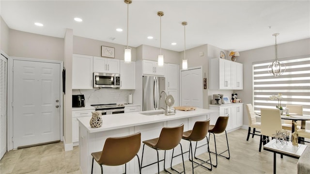 2627 Maitland Crossing Way Unit 101, Orlando, FL 32810 - kitchen with appliances with stainless steel finishes, white cabinetry, light countertops, tasteful backsplash, and recessed lighting