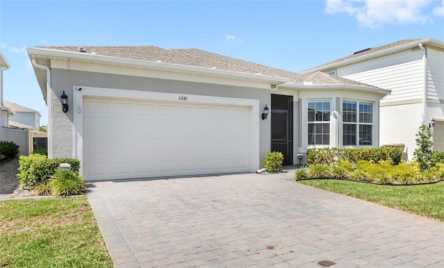 5641 Oak Knoll Dr, Saint Cloud, FL 34771 - ranch-style home with stucco siding, decorative driveway, and an attached garage