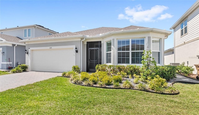 5641 Oak Knoll Dr, Saint Cloud, FL 34771 - view of front of property with a garage, decorative driveway, a front yard, and stucco siding