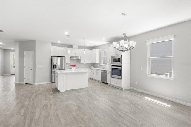 5641 Oak Knoll Dr, Saint Cloud, FL 34771 - kitchen featuring stainless steel appliances, open floor plan, a chandelier, under cabinet range hood, and recessed lighting