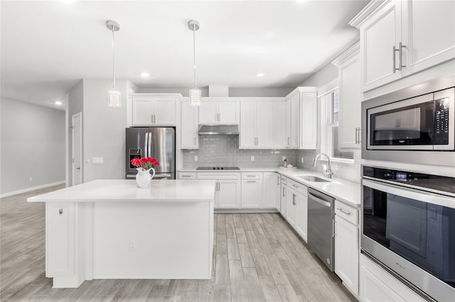 5641 Oak Knoll Dr, Saint Cloud, FL 34771 - kitchen featuring stainless steel appliances, a sink, under cabinet range hood, a center island, and light wood-type flooring