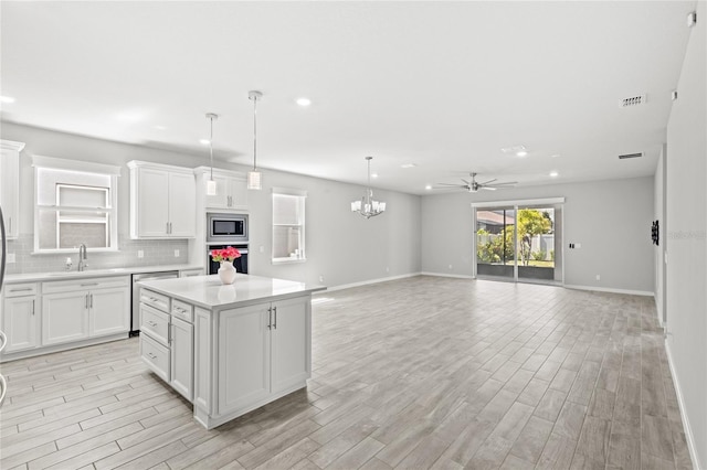 5641 Oak Knoll Dr, Saint Cloud, FL 34771 - kitchen with stainless steel appliances, ceiling fan, light countertops, a sink, and baseboards