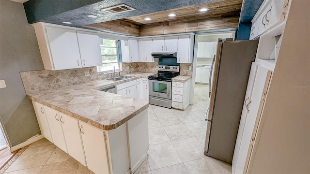 2928 NE 14th Ave, Ocala, FL 34479 - kitchen featuring appliances with stainless steel finishes, a peninsula, a sink, backsplash, and light tile patterned floors