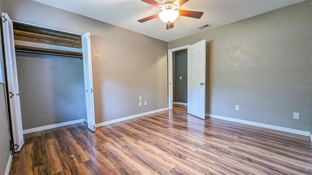 2928 NE 14th Ave, Ocala, FL 34479 - unfurnished bedroom with wood finished floors, baseboards, a ceiling fan, a closet, and a textured wall
