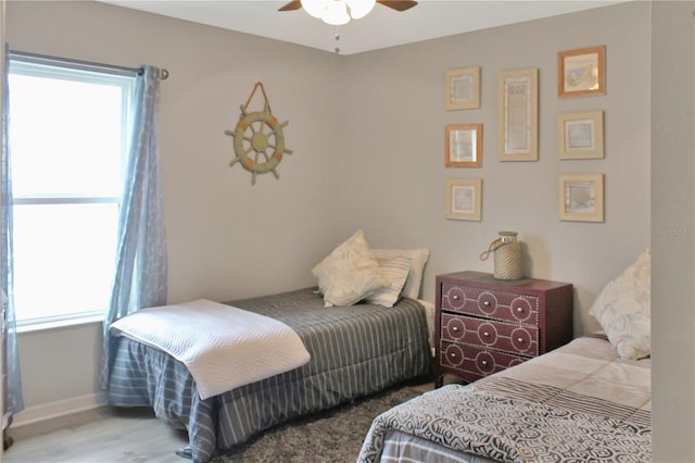 2835 Mosshire Cir, Saint Cloud, FL 34772 - bedroom with multiple windows, wood finished floors, a ceiling fan, and baseboards