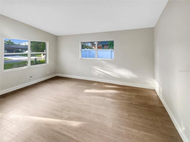 1736 Taylor Lake Pl, Largo, FL 33778 - empty room with wood finished floors, baseboards, and lofted ceiling