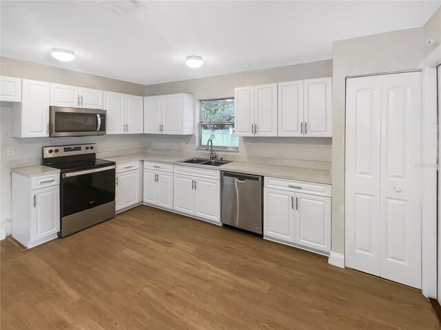 1736 Taylor Lake Pl, Largo, FL 33778 - kitchen with stainless steel appliances, a sink, white cabinetry, and light countertops