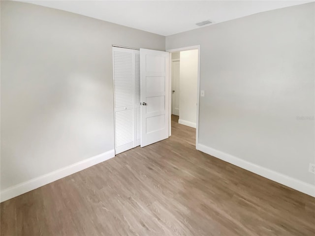 1736 Taylor Lake Pl, Largo, FL 33778 - unfurnished bedroom with baseboards, a closet, and wood finished floors