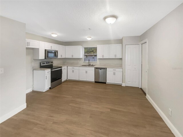 1736 Taylor Lake Pl, Largo, FL 33778 - kitchen with stainless steel appliances, a sink, light countertops, and baseboards