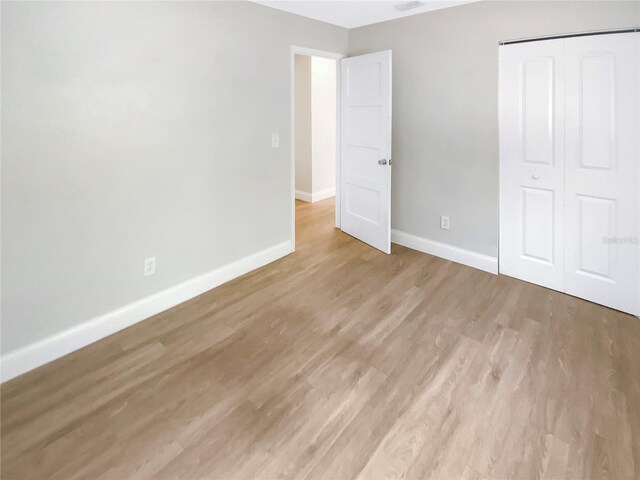 1736 Taylor Lake Pl, Largo, FL 33778 - unfurnished bedroom featuring baseboards, light wood finished floors, and a closet