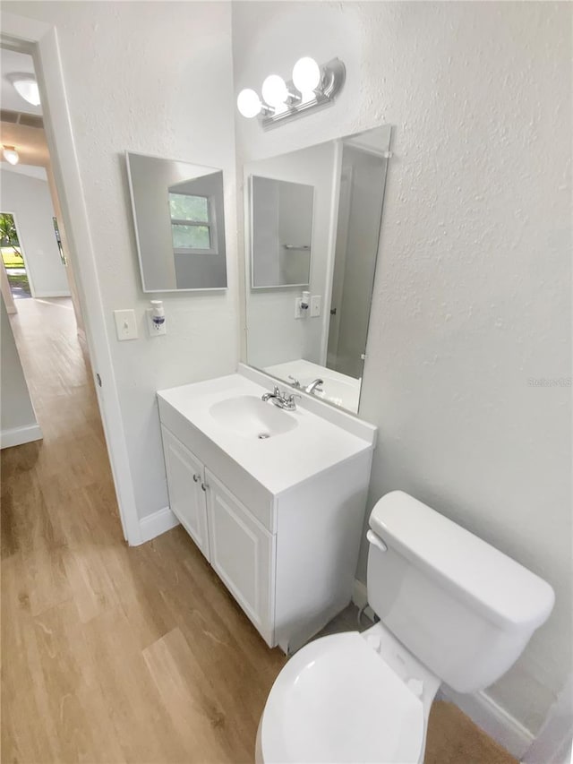 1736 Taylor Lake Pl, Largo, FL 33778 - bathroom with wood finished floors, toilet, vanity, a textured wall, and baseboards