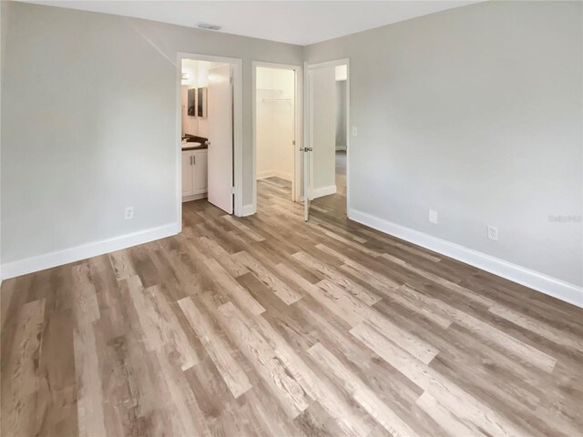 1736 Taylor Lake Pl, Largo, FL 33778 - unfurnished bedroom featuring baseboards, light wood finished floors, a spacious closet, and a closet