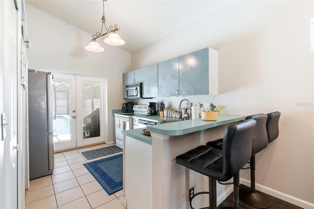 2903 Willow Oak Ct, Kissimmee, FL 34744 - kitchen with appliances with stainless steel finishes, a peninsula, a kitchen bar, french doors, and decorative light fixtures