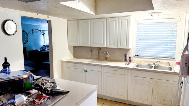 4719 Alcazar Way S, Saint Petersburg, FL 33712 - kitchen featuring a sink, light tile patterned floors, white cabinetry, light countertops, and a textured ceiling