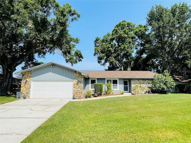 3565 E Lake Dr, Land O Lakes, FL 34639 - single story home with stone siding, an attached garage, a front yard, and concrete driveway