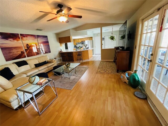 3565 E Lake Dr, Land O Lakes, FL 34639 - living room with light wood finished floors, lofted ceiling, ceiling fan, and a textured ceiling