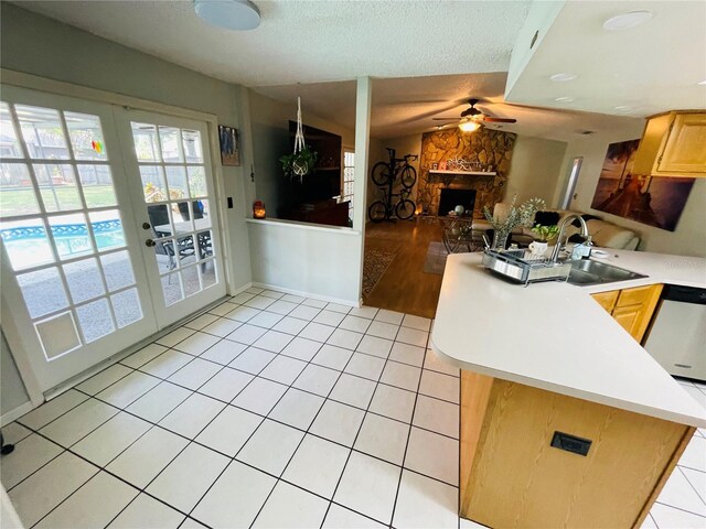 3565 E Lake Dr, Land O Lakes, FL 34639 - kitchen with a peninsula, french doors, a stone fireplace, ceiling fan, and stainless steel dishwasher