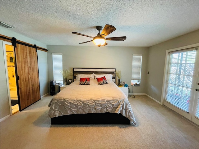 3565 E Lake Dr, Land O Lakes, FL 34639 - carpeted bedroom with a barn door, a textured ceiling, a ceiling fan, and baseboards
