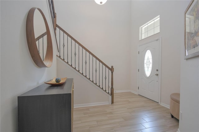 5908 Paxton Ct, Apopka, FL 32703 - entryway featuring stairway, wood finished floors, baseboards, and a towering ceiling