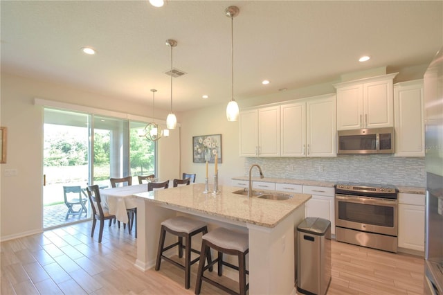 5908 Paxton Ct, Apopka, FL 32703 - kitchen with stainless steel appliances, a sink, backsplash, white cabinetry, and recessed lighting