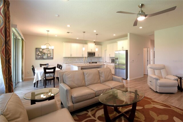 5908 Paxton Ct, Apopka, FL 32703 - living area with light wood-type flooring, baseboards, a ceiling fan, recessed lighting, and a chandelier