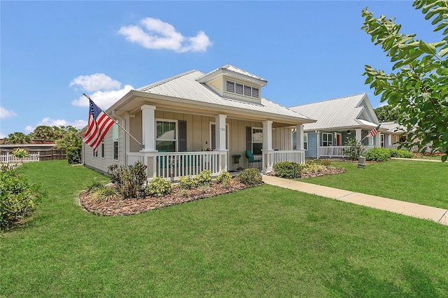 106 Turtle Run, Umatilla, FL 32784 - view of front facade with board and batten siding, covered porch, a front yard, and metal roof