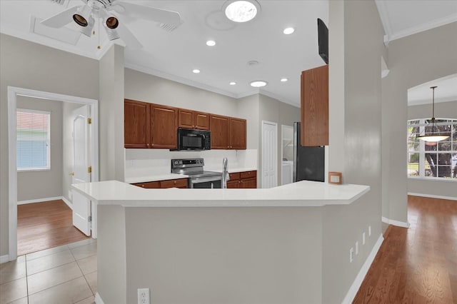 3304 Bennington Ct, Winter Park, FL 32792 - kitchen with stainless steel electric range oven, black microwave, ornamental molding, ceiling fan, and baseboards