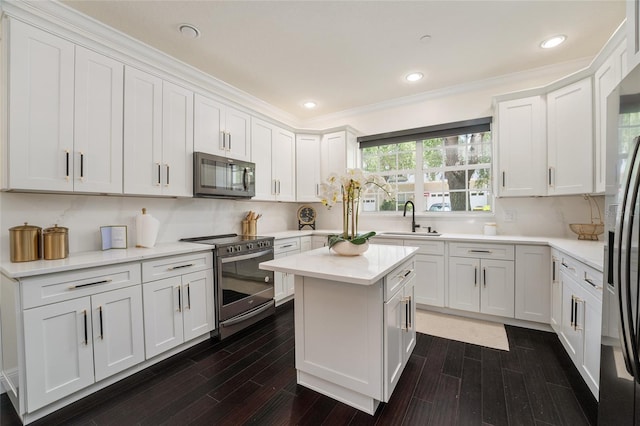 152 Riggings Way, Clermont, FL 34711 - kitchen featuring appliances with stainless steel finishes, a sink, dark wood-type flooring, light countertops, and white cabinetry