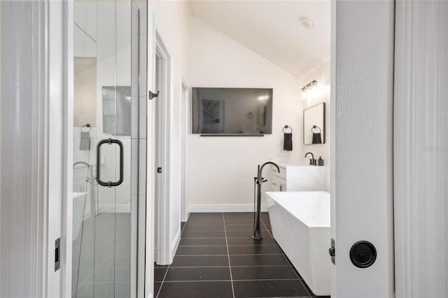 152 Riggings Way, Clermont, FL 34711 - full bath with vaulted ceiling, tile patterned floors, a freestanding tub, a shower stall, and baseboards