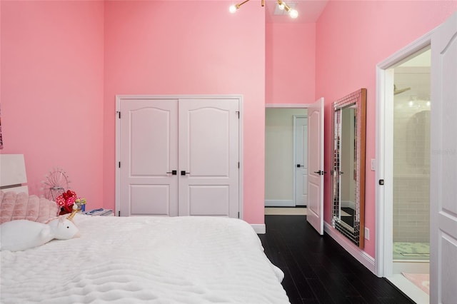 152 Riggings Way, Clermont, FL 34711 - bedroom featuring dark wood-style flooring, a high ceiling, a closet, baseboards, and ensuite bath