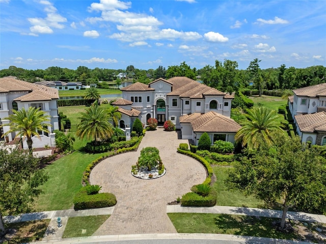 4071 Isabella Cir, Windermere, FL 34786 - mediterranean / spanish house featuring curved driveway, a tiled roof, and view of wooded area