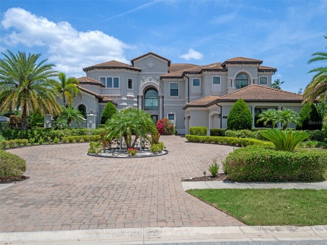4071 Isabella Cir, Windermere, FL 34786 - mediterranean / spanish house with curved driveway, a tiled roof, and stucco siding