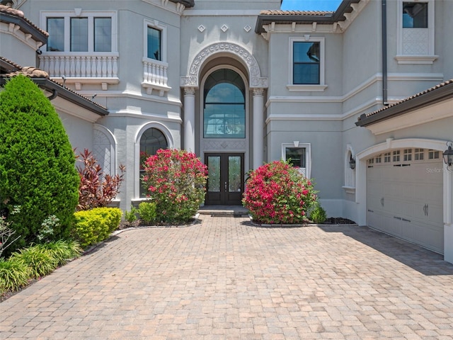 4071 Isabella Cir, Windermere, FL 34786 - doorway to property featuring french doors, a garage, decorative driveway, and stucco siding