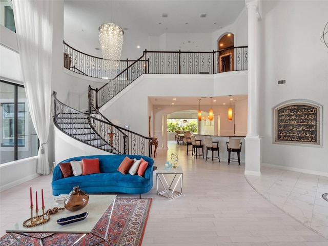 4071 Isabella Cir, Windermere, FL 34786 - living room with decorative columns, a towering ceiling, a chandelier, stairs, and baseboards