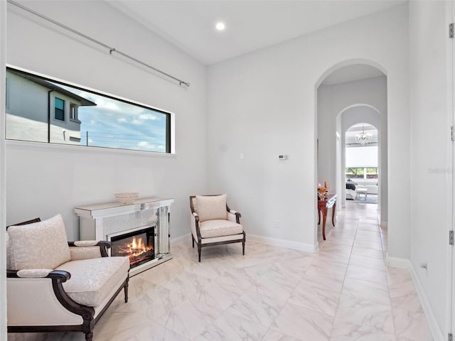 4071 Isabella Cir, Windermere, FL 34786 - living area with light marble finish flooring, a glass covered fireplace, arched walkways, baseboards, and recessed lighting