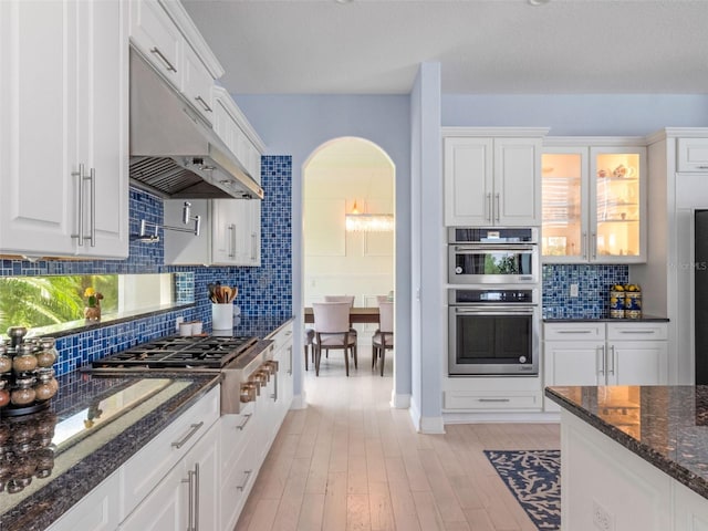 4071 Isabella Cir, Windermere, FL 34786 - kitchen with under cabinet range hood, stainless steel appliances, white cabinets, and backsplash