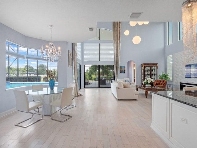 4071 Isabella Cir, Windermere, FL 34786 - dining room featuring a chandelier, a high ceiling, light wood finished floors, and arched walkways