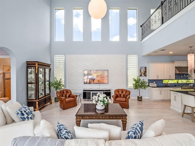 4071 Isabella Cir, Windermere, FL 34786 - living room with arched walkways, a towering ceiling, healthy amount of natural light, and light wood-style floors