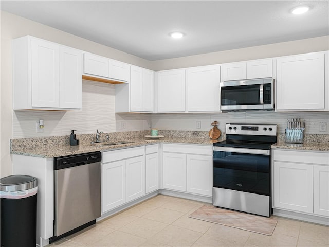 440 Patricia Alford Dr, Haines City, FL 33844 - kitchen featuring stainless steel appliances, a sink, white cabinets, light stone countertops, and recessed lighting