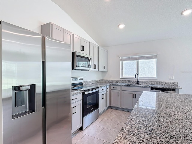 2836 Sanctuary Dr, Clermont, FL 34714 - kitchen featuring appliances with stainless steel finishes, a sink, lofted ceiling, dark stone counters, and gray cabinets