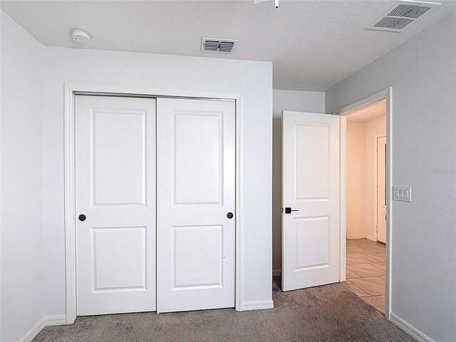 2836 Sanctuary Dr, Clermont, FL 34714 - unfurnished bedroom featuring carpet floors, baseboards, a closet, and a textured ceiling
