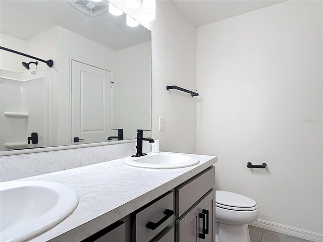 2836 Sanctuary Dr, Clermont, FL 34714 - bathroom with double vanity, toilet, baseboards, tile patterned flooring, and a shower