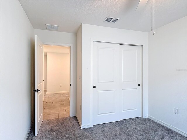 2836 Sanctuary Dr, Clermont, FL 34714 - unfurnished bedroom featuring carpet flooring, a closet, baseboards, and a textured ceiling