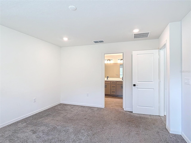 2836 Sanctuary Dr, Clermont, FL 34714 - unfurnished bedroom with light carpet, baseboards, recessed lighting, a sink, and connected bathroom