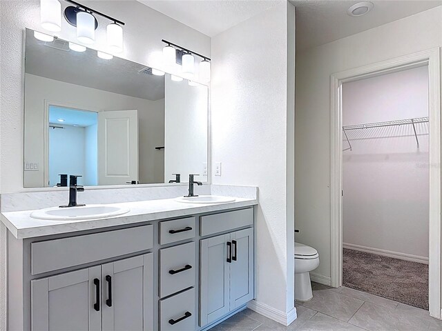 2836 Sanctuary Dr, Clermont, FL 34714 - bathroom featuring double vanity, tile patterned flooring, a walk in closet, and toilet