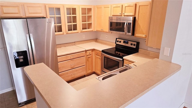5000 Culbreath Key Way Unit 9-101, Tampa, FL 33611 - kitchen featuring stainless steel appliances, light brown cabinets, a sink, and glass insert cabinets