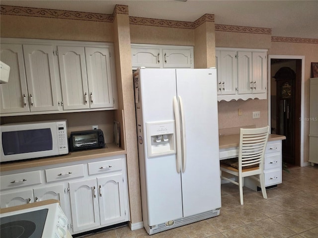 579 Rockingham Rd, Orange Park, FL 32073 - kitchen with white appliances, white cabinetry, light countertops, and light tile patterned floors