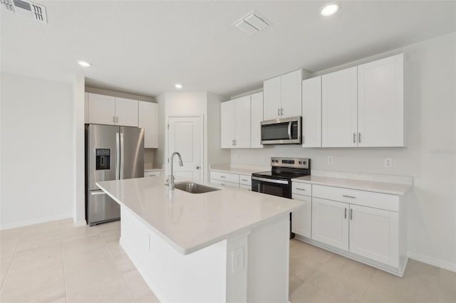 1855 Brekey Way, Zephyrhills, FL 33541 - kitchen featuring appliances with stainless steel finishes, white cabinets, a kitchen island with sink, light countertops, and recessed lighting