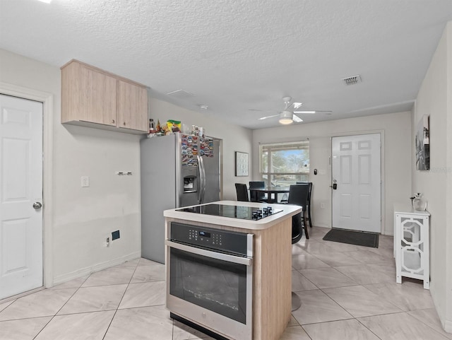 4546 Malibu St, Orlando, FL 32811 - kitchen with stainless steel appliances, light brown cabinets, light countertops, a ceiling fan, and a kitchen island
